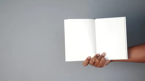 Holding an empty notebook against a plain gray background Stock Footage 303614459