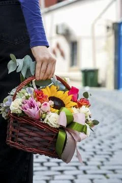 Holding a flower basket while walking on a cobblestone street in autumn 库存照片