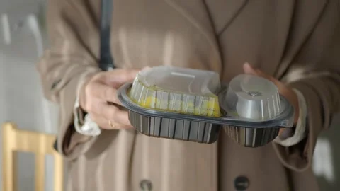 Holding a food container in a casual setting Stock Footage 344355702