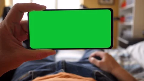 Holding a Green Screen Smartphone while Lying on the Bed Stock Footage 133594621
