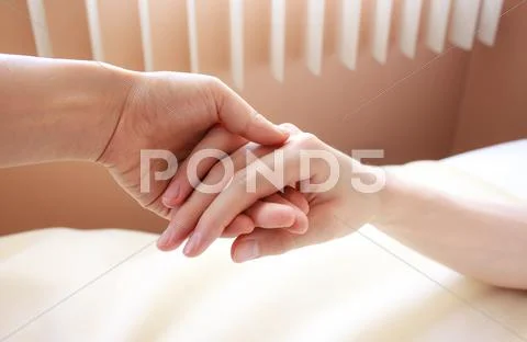 Holding hand of a sick loved one Stock Photos
