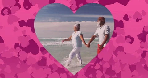 Holding hands, elderly couple walking on beach with heart shapes around them Stock Footage 305122077