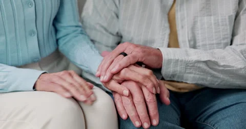 Holding hands, support and senior couple on sofa for care, commitment and Stock Footage 338023065