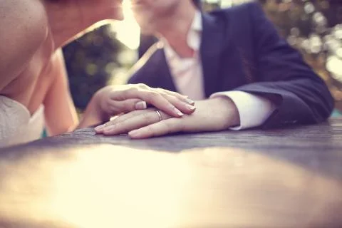 Holding hands with wedding ring in the sunlight Stock Photos