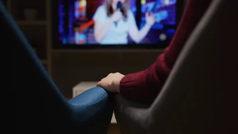 Holding hands while watching tv Stock Footage 99942282