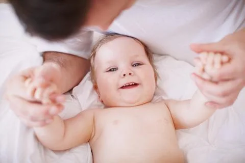 Holding onto her little hands. A devoted young dad holding onto his baby Stock Photos