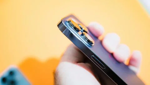 Holding iPhone 14 Pro with Yellow BG Stock Photos