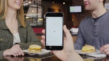 Holding iPhone in restaurant with couple Stock Footage 86127947