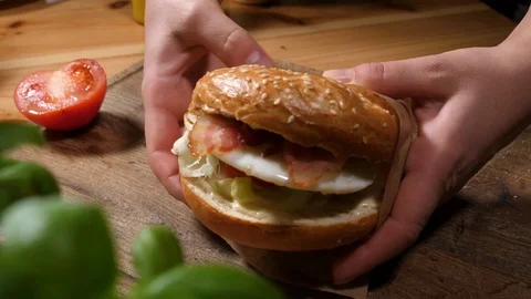 Holding just cooked fresh baigel during breakfast in cafe bistro Stock Footage 84699141