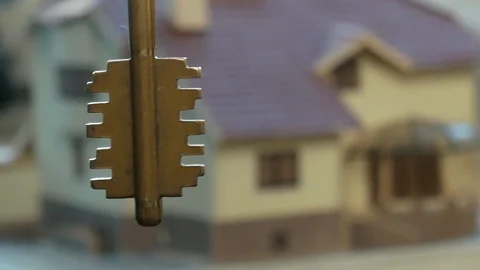 Holding a key on the cottage model background Stock Footage 118778973