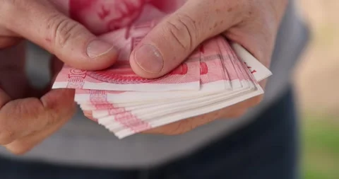 Holding a large stack of Chinese yuan in his hand on a background, holding a Stock Footage 312164217