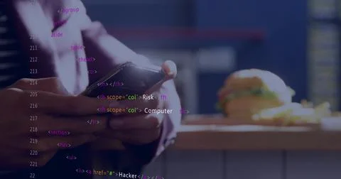 Holding man in dark jacket tapping phone at cafe counter, with burger, fries, 스톡 사진