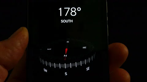Holding a mobile phone with compass app displayed. Vídeos de archivo 65326344