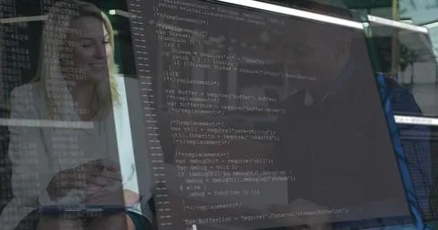 Holding notepad, colleagues in light blouse and dark blazer reviewing code on Stock Photos