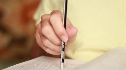 Holding a pencil under a book Video stock 75025980