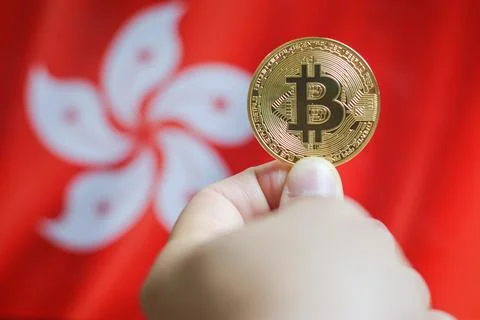 Holding a physical version of Bitcoin (the new virtual currency) and a Hong.. Stock Photos