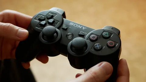 Holding a Playstation 3 controller, classic dualshock design Stock-Footage 107269221