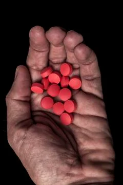 Holding red pills Stock Photos