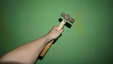 Holding a small hammer with the left hand Stock Photos