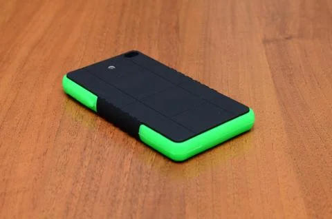 Holding a smart phone while charging with solar charger in white background Stock Photos