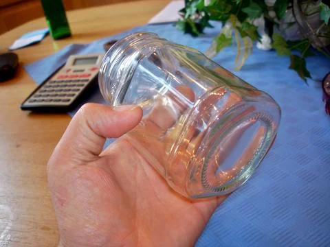 Holding a Square Glass Jar While Working at a Cozy Home Desk During a Produ.. Stock Photos