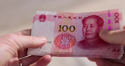 Holding a stack of Chinese yuan in his hand on a background, holding a large Stock Footage 314274490