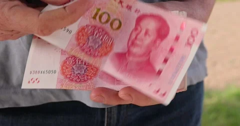 Holding a stack of red yuan in hand on a background, holding a large amount of Stock Footage 314726762