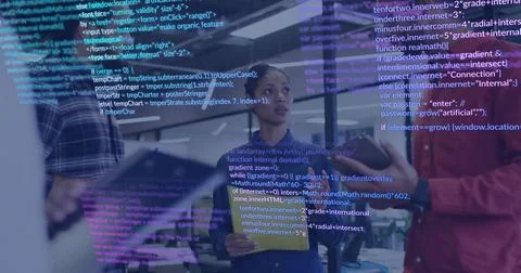 Holding tablet denim-jacketed engineer listening in open office, with code Foto stock