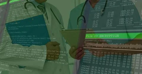 Holding tablet, folder, two doctors wearing white coat, blue scrubs reviewing Stock Photos