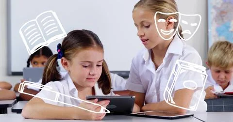 Holding tablets, two students in white shirts leaning over tablet in classroom Fotos Stock