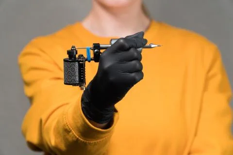 Holding a tattoo machine on a light background Stock Photos