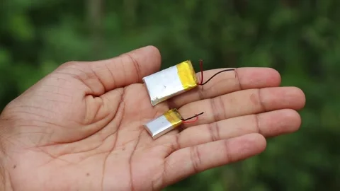 Holding two small lithium polymer battery cells Stock Footage 346665394