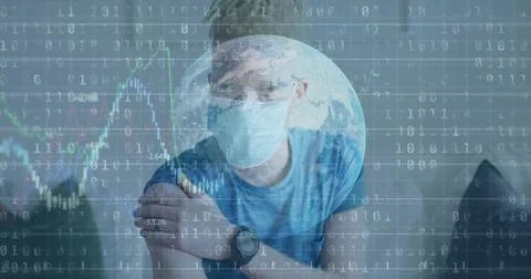 Holding upper arm, masked man wearing blue tee sitting in neutral room, watch Stock Photos