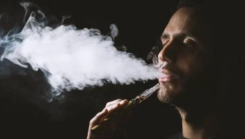 Holding vaping device or electronic cigarette Stock Photos