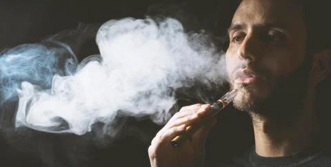 Holding vaping device or electronic cigarette Stock Photos