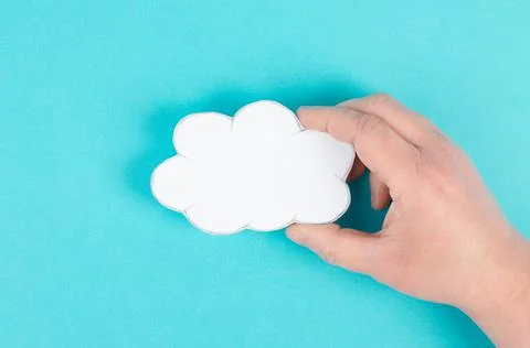 Holding a white cloud in the hand, empty copy space for text, blue background, Stock Photos