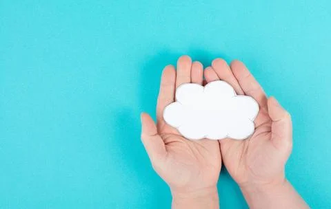 Holding a white cloud in the hand, empty copy space for text, blue backgro... 스톡 사진