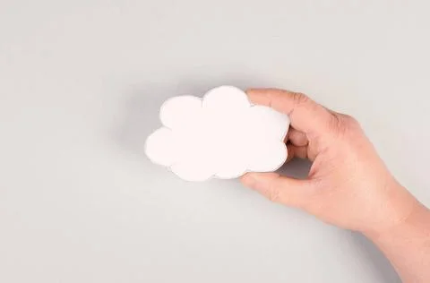 Holding a white cloud in the hand, empty copy space for text, gray backgro... Foto stock