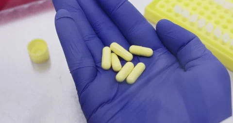 Holding yellow capsules Stock Footage 310515615