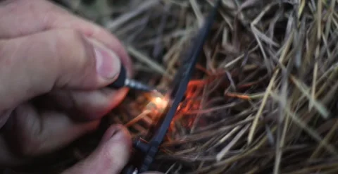 Holds fire in his hands. Lights a bonfire. . survival in the mountains Stock Footage 166399789