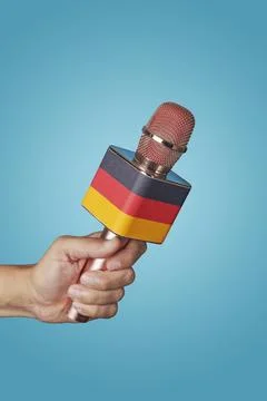 Holds a microphone patterned with the german flag Stock Photos