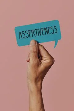 Holds a sign with the text assertiveness Stock Photos