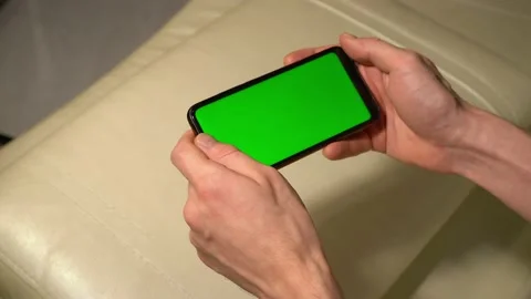 Holds a smartphone with a green screen Video stock 142907367