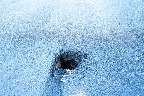 Hole in blue rubber surface 库存照片