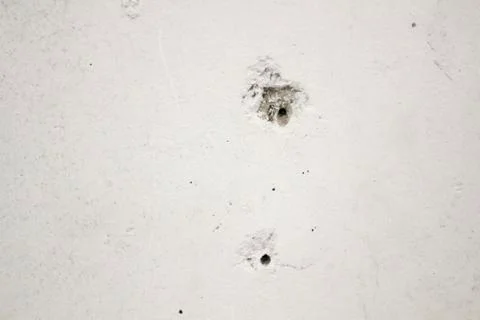 Hole from a bullet in a concrete wall, texture, background Stock Photos