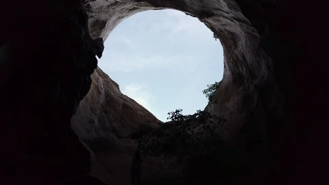The hole into the ceiling of cave. View from the darkness to light Stock Footage 114444969