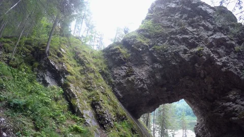 Hole in cliff somewhere in Ural mountains. Touristic path among trees. Natural Stock Footage 121337529