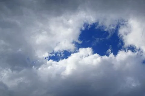 Hole in the cloud...Glimpse of the sky in the clouds...Blue sky breaking thro Stock Photos
