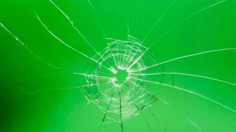 A hole with cracks in the glass. Broken window on a green background Stock Illustration