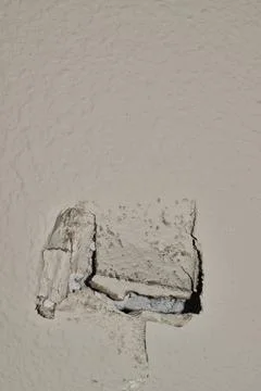 Hole damage to an interior section of white drywall with copy space above. Stock Photos